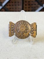 Front view showing crown, sunburst and laurel wreath design