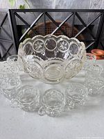 Punch bowl with nine handled cups arranged around it