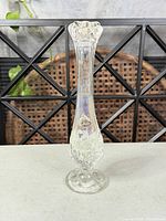 Full view of Fenton iridescent clear glass bud vase showing overall shape and relief pattern