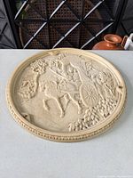 Full view of round bas-relief plaque on tabletop