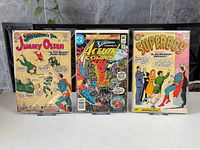 Front covers of all three comic books standing on easels