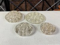 All four clear glass flower frogs grouped