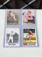 All four cards in protective sleeves displayed on table