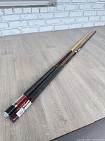 Full length view of both pool cues on floor