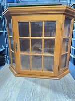Front view of cabinet showing glass-pane door and oak finish