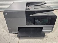 Front and side view of HP Officejet Pro 8610 showing overall condition and output tray