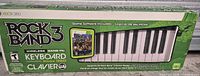 Front of retail box showing Rock Band 3 branding, keyboard graphic and included game artwork