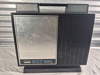 Front view of Montgomery Ward 807 Duo Eight projector showing brushed silver panel and grille