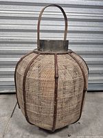 Full view of lantern showing wood ribs, jute weave, handle