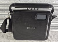 Front view of Shinco speaker showing grille, logo, carry handle and strap