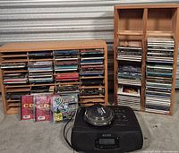 Full lot with Sony player, disc cleaner, two wooden racks filled with CDs
