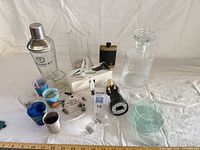 Full lot overview showing shaker, pitcher, decanter, flask, shot glasses, coasters, ornament and openers