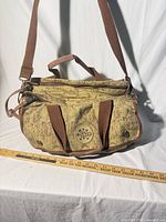 Full view of bag with shoulder strap, top handles, ruler for scale