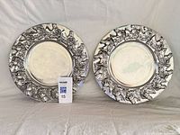 Both pewter trays front view showing horse motif borders
