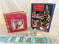 Lot overview showing two hardcover books, ceramic Delft house figurine, and folded leaflet