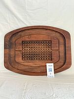 Front view of large carved wood platter showing grid pattern and overall shape