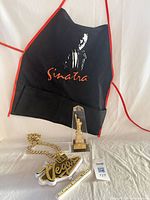Group shot of apron, necklace and trophy