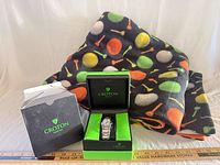Watch in branded box beside folded fleece throw