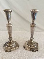 Front view of both candlesticks showing design and tarnish