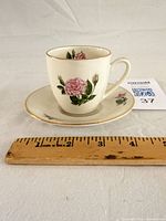 Teacup on saucer next to ruler showing scale