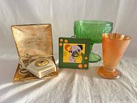 All four items grouped: shaver in box, green vase, orange carnival glass tumbler, pug canvas