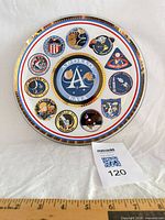 Front view of plate showing coloured mission patches and central Apollo logo