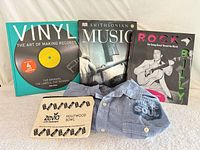 Group shot of three books, chambray shirt, and canvas pouch