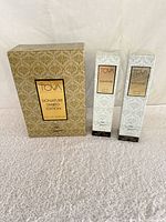 Three TOVA Signature perfume boxes: one large gold patterned gift box and two smaller white patterned retail boxes