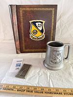 Album, pewter mug, small plaque displayed together