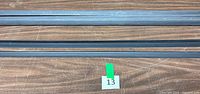 Three of the black plastic corner mold strips showing 90-degree profile