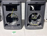Front view showing empty woofer and horn openings, internal wiring visible