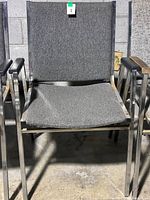 Front view of middle grey-upholstered chair, shows chrome frame and padding