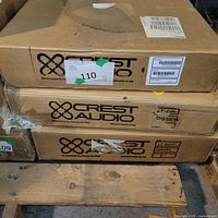 Three boxed Crest Audio amplifiers on pallet