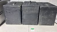 Front view of three black wooden road cases showing size, handles, general wear