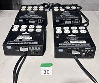 Four Leviton DDS-5600 dimmer packs top view showing outlet banks and power cords