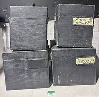 Front view of four black wooden road cases showing size differences and exterior wear