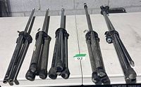 Five folded nickel microphone stands on table