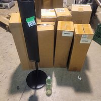Front view of a speaker on stand with boxed units behind