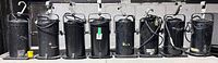 Front view of eight black PAR 38 cans aligned showing housings, clamps, cords