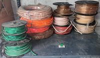 Stacked spools and rolls of multi-colour UV fluorescent tubing on shelf