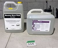 Two sealed haze fluid jugs side by side showing labels and sizes