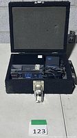Open road case showing Nady 101XT receiver, bodypack transmitter, AC adapter in foam interior