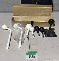 All mounting hardware laid out: bracket base, shafts, nut bags