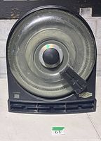 Front view showing circular slot track, center knob, side eject lever, TomBox logo