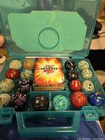 Open storage case showing cards and Bakugan spheres