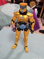 Front view of the action figure standing upright with accessory on left arm