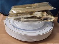 plates and wrapped gold cutlery stacked together