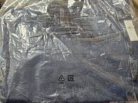 Jeans in sealed plastic showing denim color and packaging