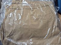 Front view of khaki jeans in sealed plastic