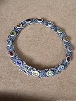 Front view showing full bracelet with multicoloured stones set in textured sterling links